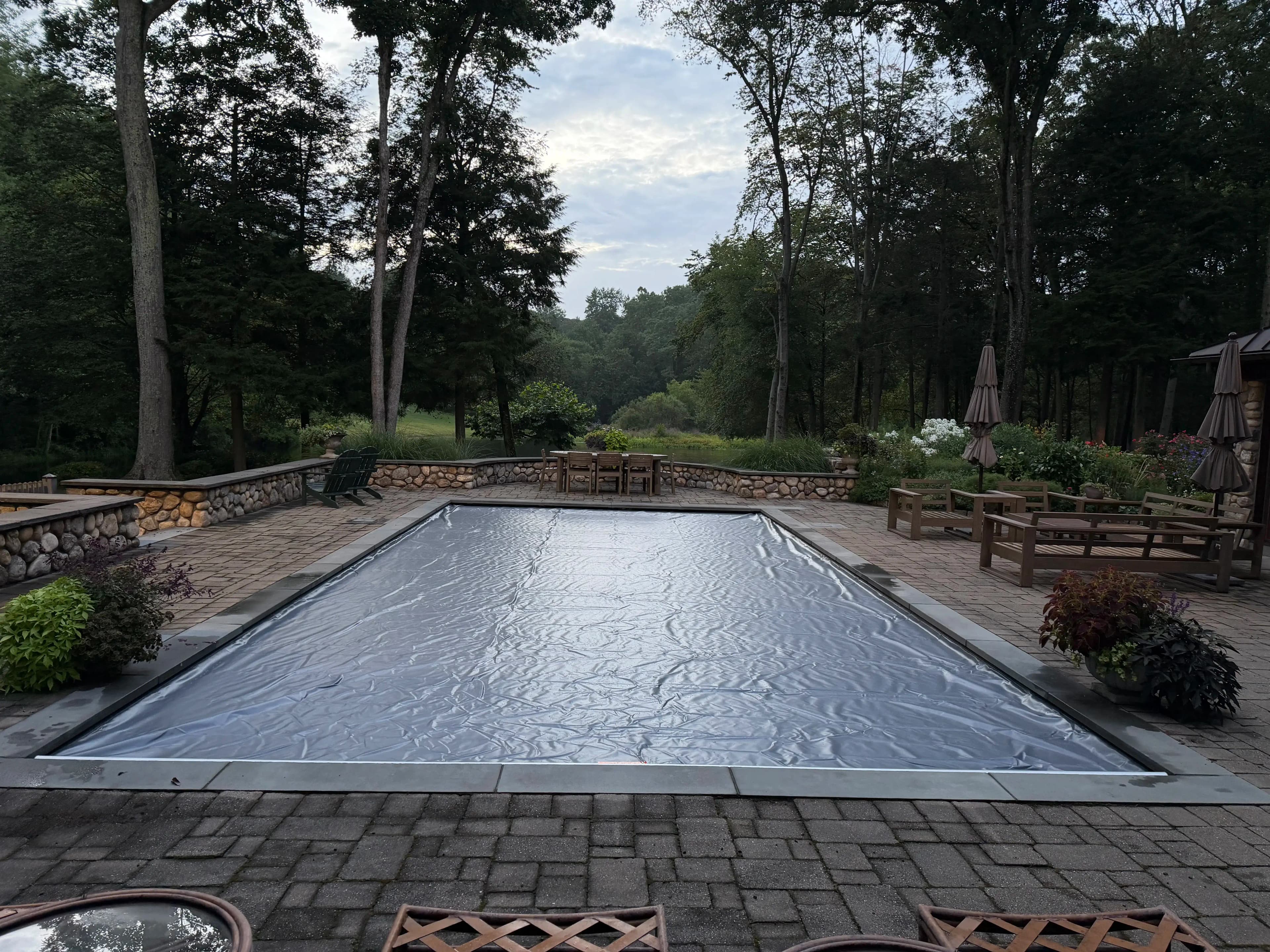 Automatic pool cover closed over a Connecticut backyard swimming pool
