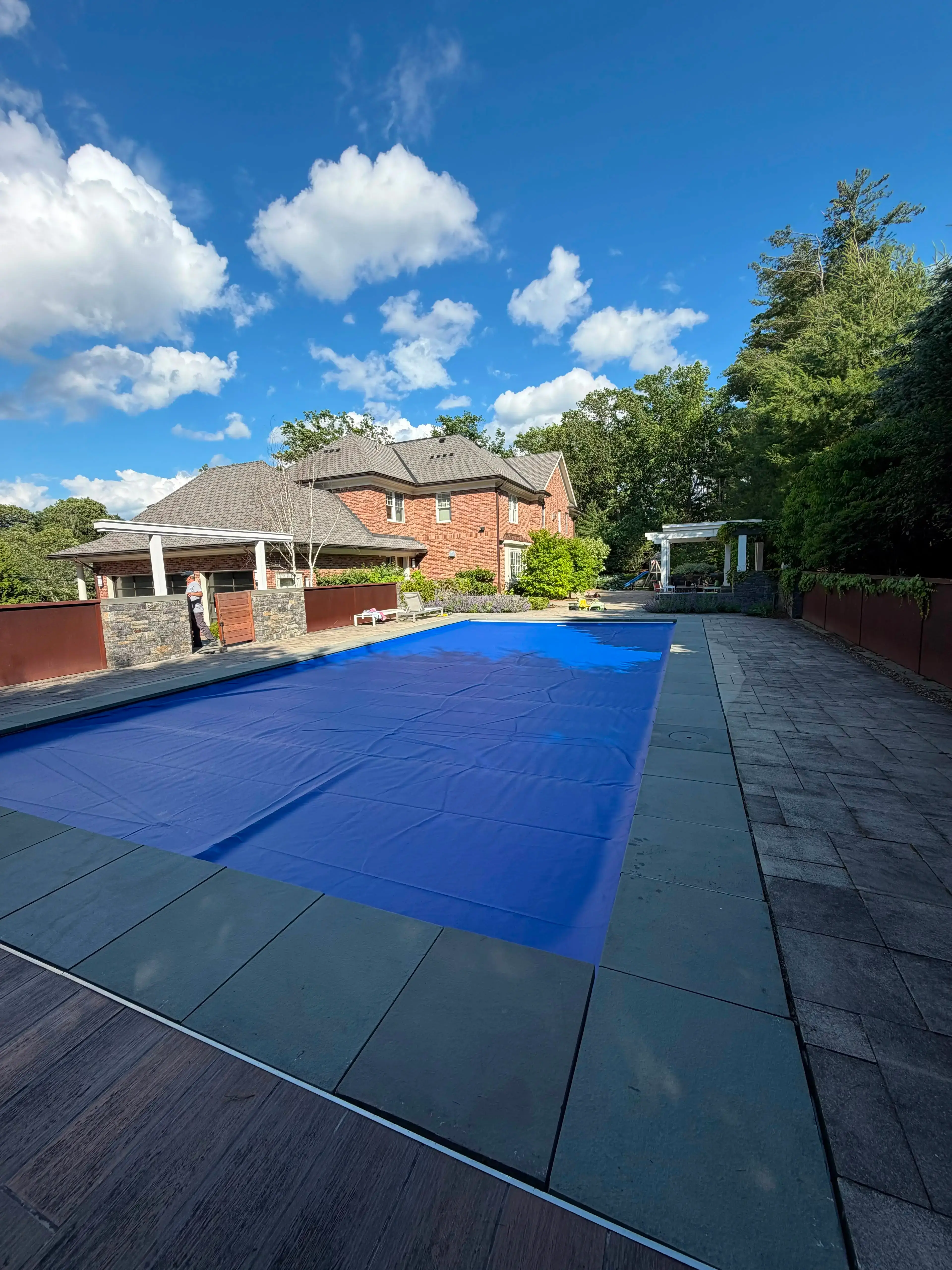 Automatic pool cover extended across a residential in-ground pool