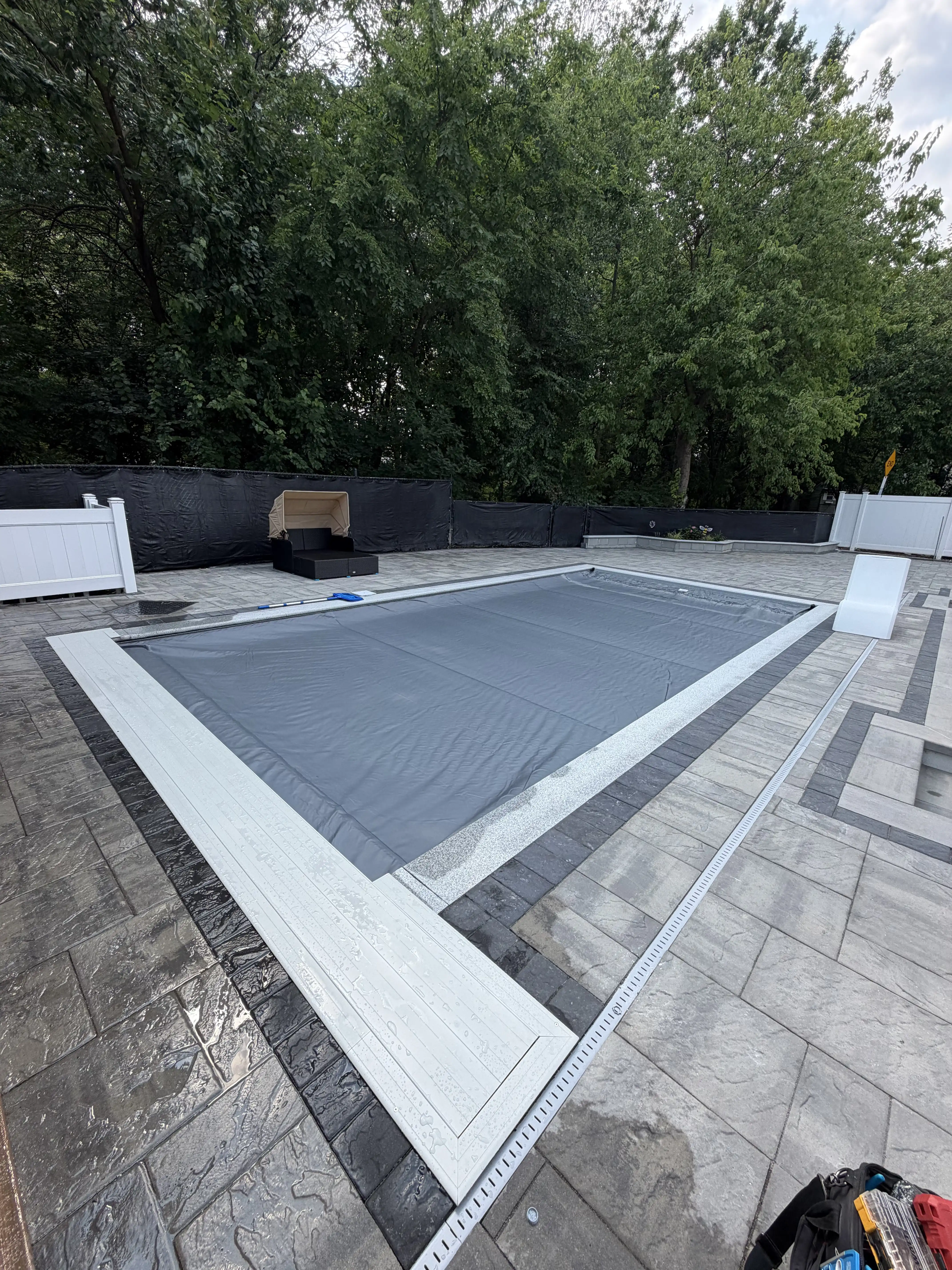 Technician performing scheduled maintenance on an automatic pool cover