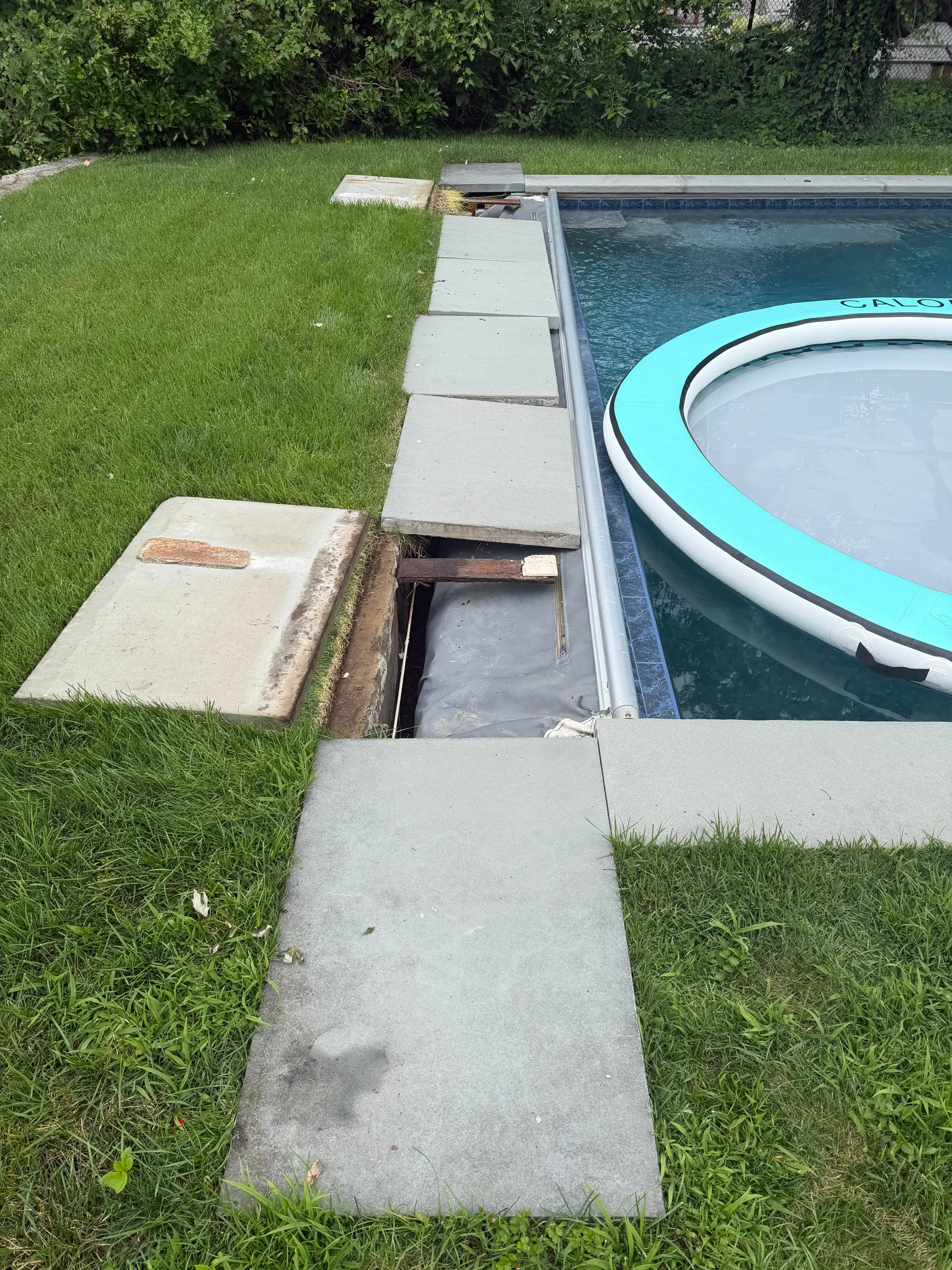 Technician repairing the drive mechanism of an automatic pool cover